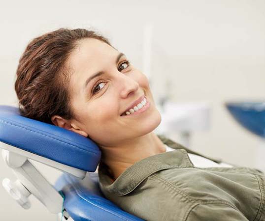 Smiling woman visiting an emergency dentist in Mesquite